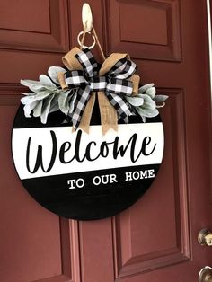 a welcome to our home sign hanging on a door