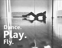 a man laying on the floor in front of a wall with words dance play fly