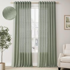 a living room with green curtains and a white chair in front of the window, next to a potted plant