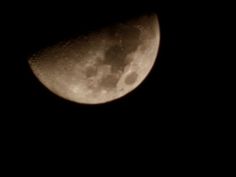 the moon is seen in the dark sky