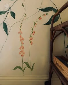 a wall with flowers painted on it and a chair in the corner next to it