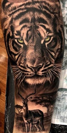 a tiger and deer tattoo on the left arm, with other animals in the background