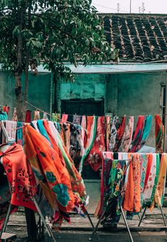 colorful clothes are drying outside in front of an old building