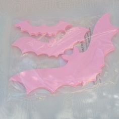 two pink bats are sitting in plastic bags