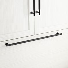 an image of a white cupboard with black handles