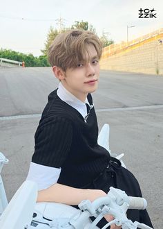 a young boy sitting on top of a white motorcycle