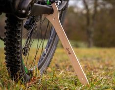 a bike with a wooden handlebar attached to it's front end in the grass