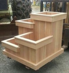 a wooden planter sitting on top of a pile of wood next to other items