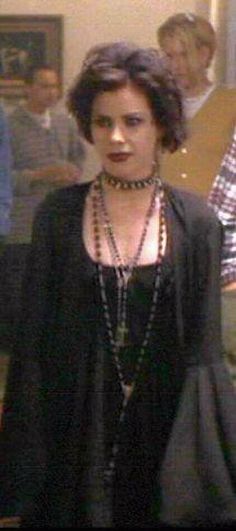 a woman standing in front of a group of people wearing pearls on her necklaces