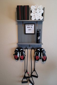 a wall mounted shelf with several pairs of skis on it and some towels in the background