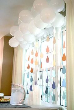 balloons are hanging from the ceiling in front of a window