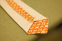 an orange and white tie laying on top of a green cloth