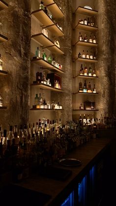 a dimly lit bar with bottles on the shelves