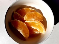 peeled oranges in a white bowl on a table