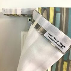 a close up of a piece of cloth with a tag on it and a tie hanging from the side