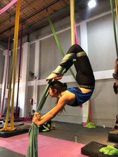 a woman doing aerial acrobatic exercises in a gym