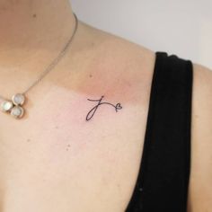 a woman's chest with the word love tattooed on her left shoulder and two pearls attached to it