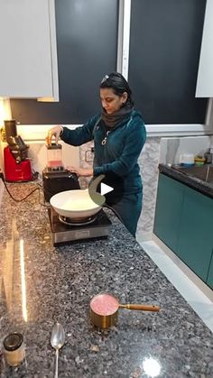 a woman standing in a kitchen preparing food on top of a stove next to utensils