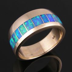 "Australian Opal Wedding Ring Australian opal and 14k gold wedding ring inlaid by Mark Hileman. This \"offset\" ring design is masterfully inlaid with 10 pieces of matching Australian opal. The opal inlay in this handmade man's ring is top quality crystal opal with bright blue and green flashes. The ring measures 10mm wide and is shown in a size 10 for scale. It will be made to order in your size and is also available in 14k white gold by special order. Many customers have selected this opal rin Wedding Band Men, Gold Cost, Opal Wedding Ring, Australian Opal Jewelry, Opal Wedding Band, Cheap Wedding Rings, 14k Gold Wedding Ring, Geode Jewelry, Australian Opal Ring