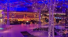 the interior of a building with blue lights and decorations on the ceiling is lit up