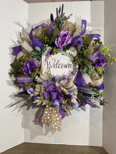 a welcome wreath with purple flowers and ribbons