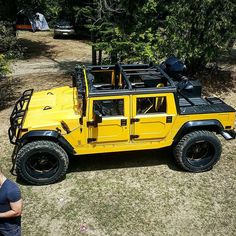 a yellow jeep parked on top of a grass covered field