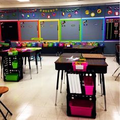 an empty classroom with desks, chairs and bulletin boards on the wall behind them