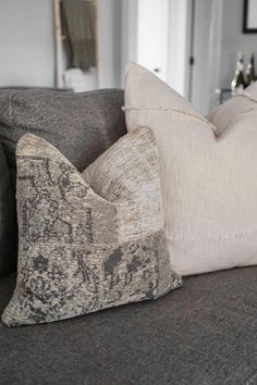 two pillows sitting on top of a gray couch