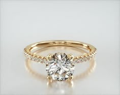 a yellow gold engagement ring with diamonds on the side