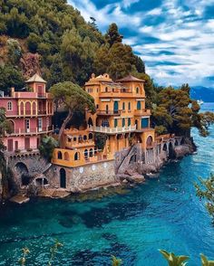 an aerial view of a house on the edge of a cliff by the ocean with trees surrounding it