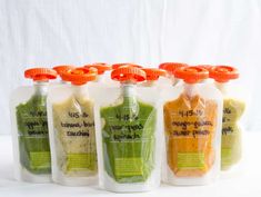 six plastic bottles filled with different types of food in each one, all labeled with orange caps