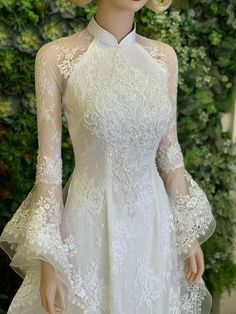 a mannequin wearing a white dress with sheer sleeves