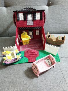 a doll house with furniture and accessories on the floor in front of a gray couch