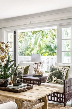 a living room filled with lots of furniture and plants on top of a wooden table