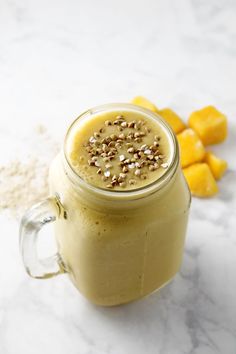 an orange smoothie in a mason jar with sprinkles on the top