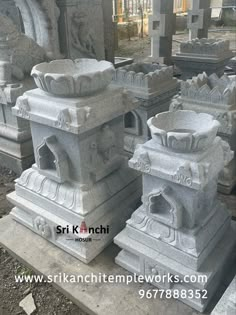 several stone urns sitting on top of cement blocks in the middle of a cemetery