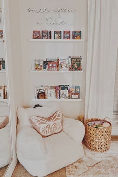 a white chair sitting in front of a mirror next to a wall with pictures on it