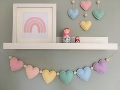 there are many hearts hanging on the shelf next to each other, including one with a rainbow