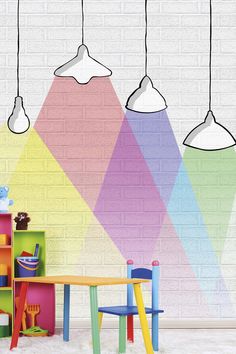 three lamps hanging over a table in front of a colorful wall