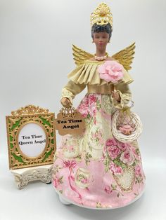 an angel figurine next to a plaque with the words tea time on it