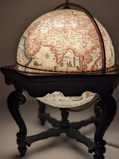 an old world globe sitting on top of a stand