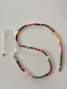 a colorful lanyard with a cell phone holder attached to the lanyard, on a white surface