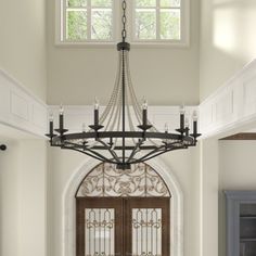 a large chandelier hangs from the ceiling in front of a doorway with an arched window