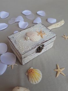 shells and seashells are scattered around an old wooden box