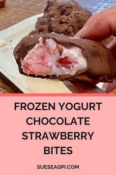 a person holding a piece of frozen yogurt chocolate strawberry bites on a plate