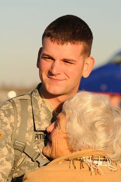 a man in uniform hugging an older woman