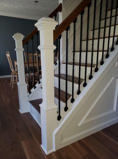 the stairs in this house are made of wood and white with black balconies