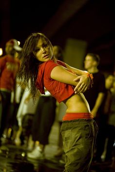 a woman in red shirt dancing on stage