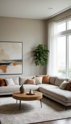 a living room filled with furniture next to a large window and a potted plant