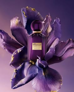 a purple flower with a bottle of perfume in it's center on a purple background